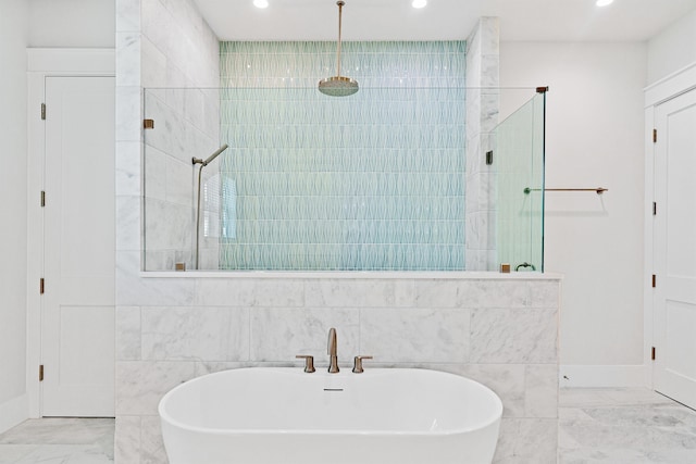 full bathroom featuring marble finish floor, a freestanding tub, a walk in shower, and recessed lighting