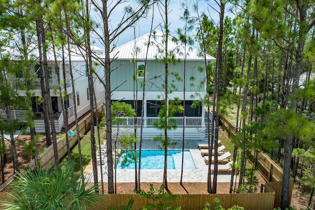 view of pool with a sunroom, a patio, fence, and a fenced in pool