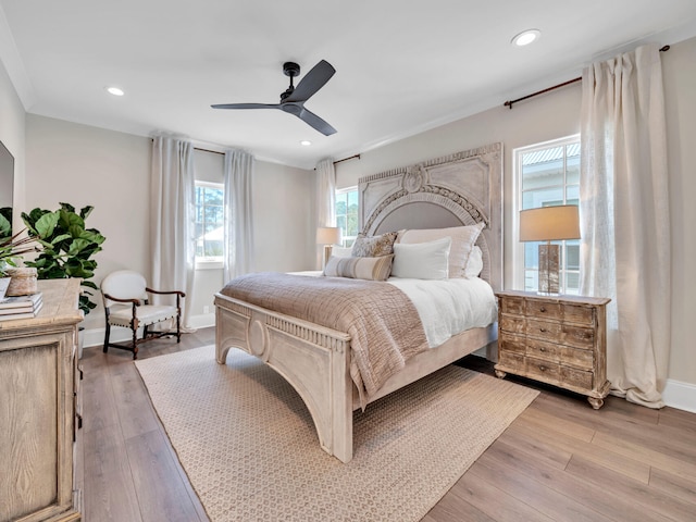 bedroom with baseboards, light wood finished floors, and recessed lighting