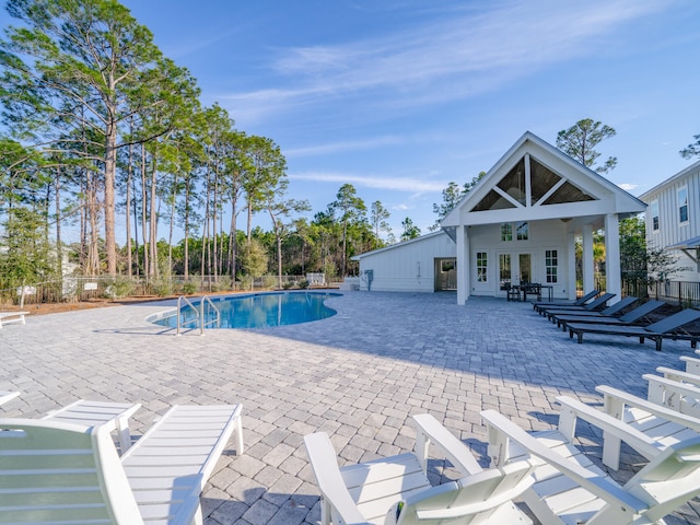 pool featuring a patio, french doors, and fence