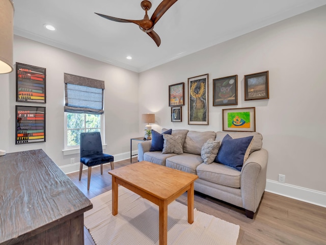 living room featuring light wood finished floors, a ceiling fan, and baseboards