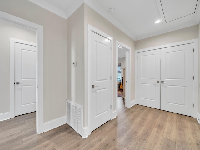 foyer with ornamental molding, light wood finished floors, visible vents, and baseboards