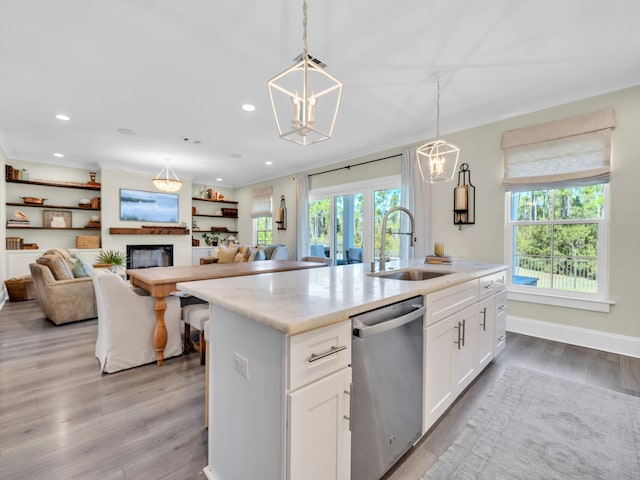 kitchen with dishwasher, open floor plan, a sink, and light wood-style floors