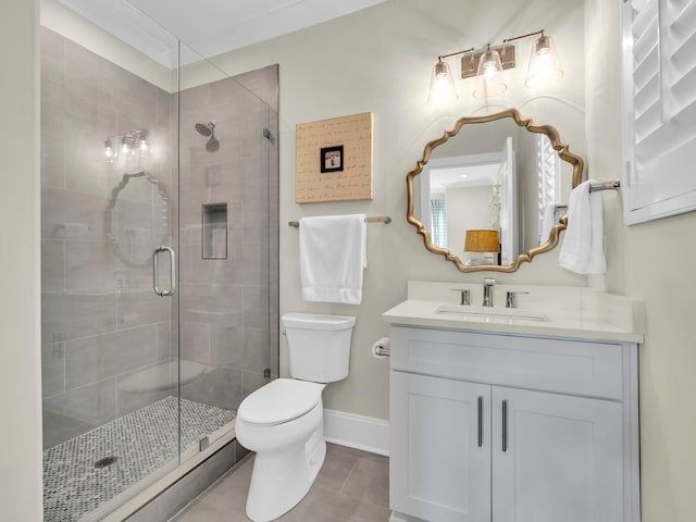 bathroom featuring vanity, a shower stall, toilet, and baseboards