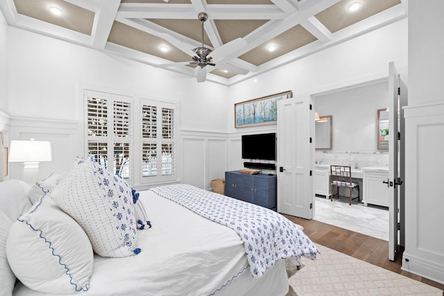 bedroom featuring coffered ceiling, dark wood-type flooring, a decorative wall, beam ceiling, and recessed lighting