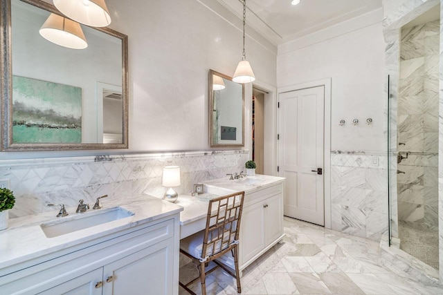 bathroom featuring marble finish floor, tile walls, ornamental molding, a sink, and a tile shower