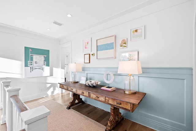 office area with a wainscoted wall, recessed lighting, visible vents, ornamental molding, and wood finished floors