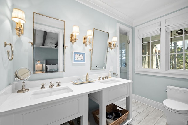 full bath featuring double vanity, a sink, toilet, and wood finished floors