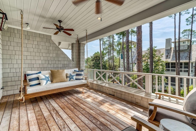 unfurnished sunroom featuring a healthy amount of sunlight, ceiling fan, and wood ceiling