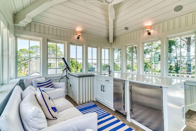 sunroom / solarium featuring a wealth of natural light, vaulted ceiling, and a sink