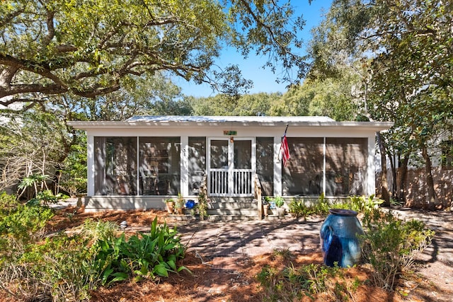 rear view of house featuring a sunroom and metal roof