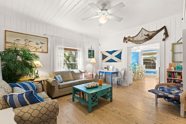 living area with ceiling fan, plenty of natural light, and hardwood / wood-style flooring