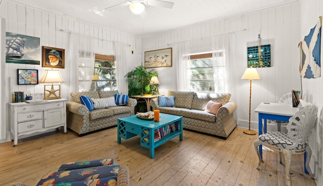 living area featuring ceiling fan, light wood finished floors, and crown molding