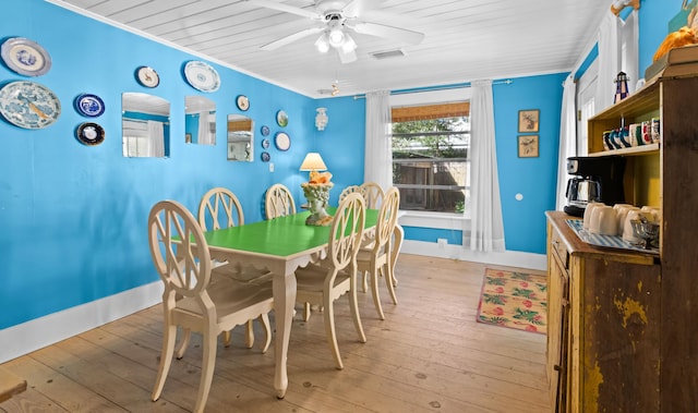 dining space featuring a ceiling fan, crown molding, light wood-style flooring, and baseboards