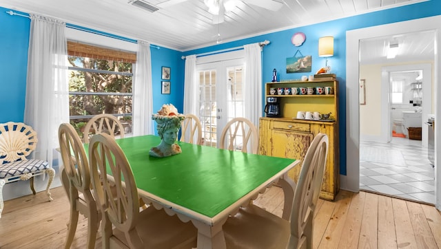 dining room with light wood-type flooring, visible vents, crown molding, and french doors