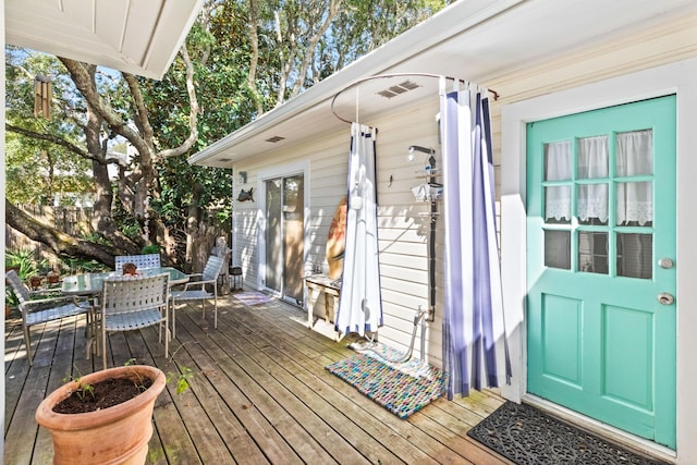 wooden deck with outdoor dining space and visible vents