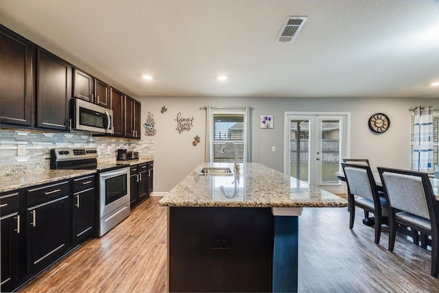 kitchen with visible vents, decorative backsplash, french doors, stainless steel appliances, and a sink