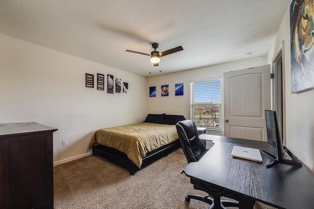 carpeted bedroom with a textured ceiling, baseboards, and a ceiling fan