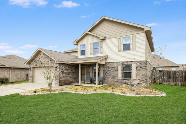 traditional home with a garage, brick siding, a front yard, and fence