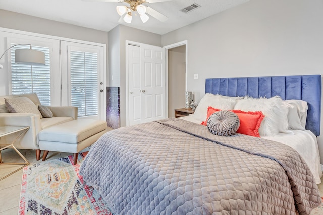 bedroom featuring tile patterned floors, visible vents, and a ceiling fan