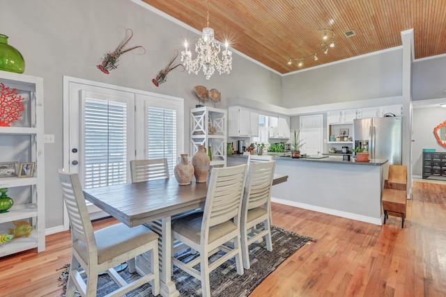 dining space with light wood finished floors, high vaulted ceiling, crown molding, wooden ceiling, and a chandelier