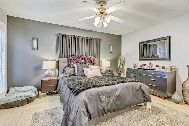 bedroom featuring light tile patterned flooring, a ceiling fan, and a textured ceiling