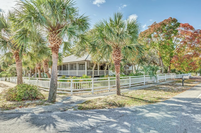 view of front of home with a fenced front yard and a sunroom