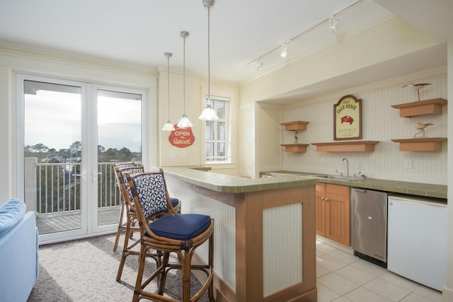 kitchen featuring open shelves, tile countertops, a kitchen breakfast bar, and a sink