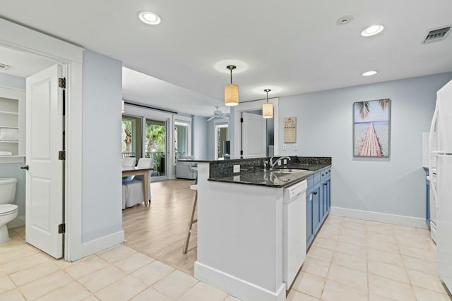 kitchen with visible vents, a breakfast bar, a sink, a peninsula, and dishwasher