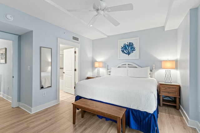 bedroom with baseboards, visible vents, light wood finished floors, ceiling fan, and ensuite bathroom