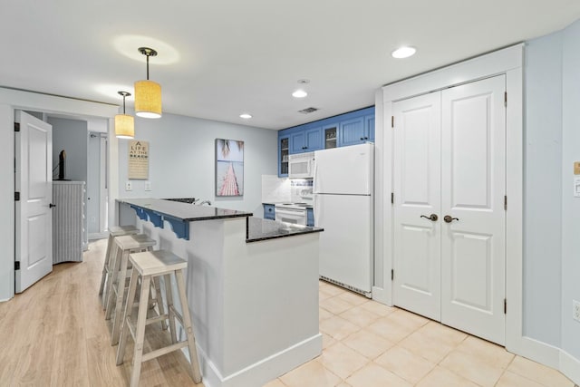 kitchen featuring visible vents, pendant lighting, blue cabinetry, a kitchen breakfast bar, and white appliances