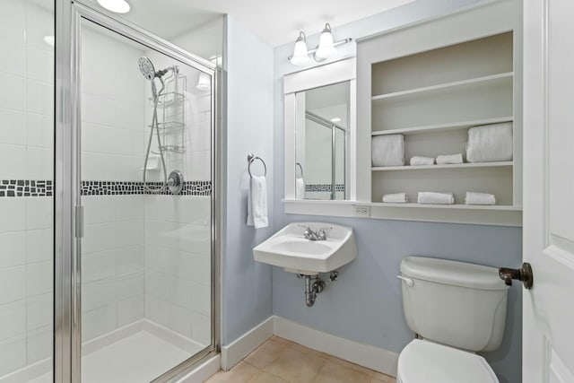 full bathroom with tile patterned floors, toilet, a sink, a shower stall, and baseboards