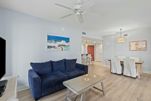 living area featuring visible vents, baseboards, and light wood-style floors