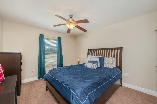 bedroom with ceiling fan, baseboards, and light colored carpet