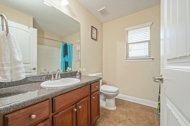 bathroom with baseboards, visible vents, toilet, a textured ceiling, and vanity