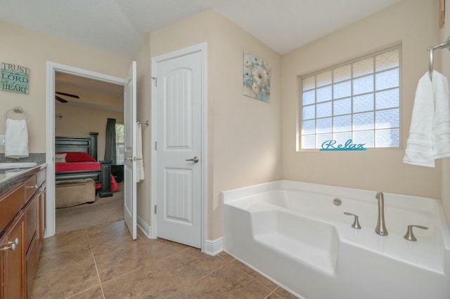 ensuite bathroom featuring vanity, baseboards, a bath, and ensuite bathroom