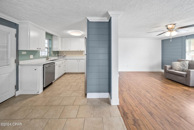 305 S Wells St, Panama City Beach, FL 32413 - kitchen featuring white cabinets, open floor plan, light countertops, stainless steel dishwasher, and a sink