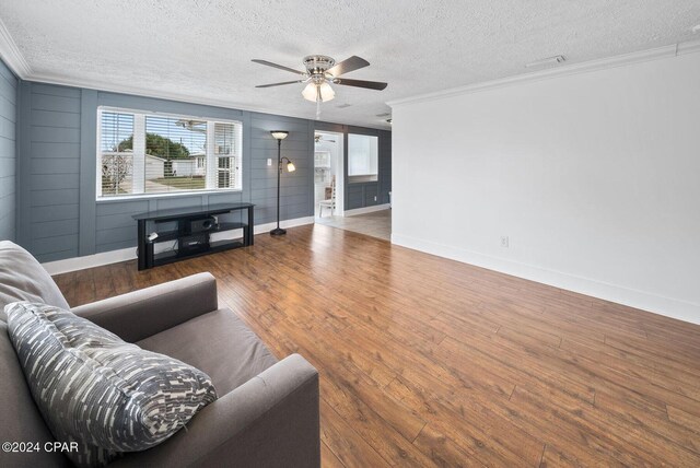 305 S Wells St, Panama City Beach, FL 32413 - living area with a textured ceiling, wood finished floors, a ceiling fan, baseboards, and crown molding
