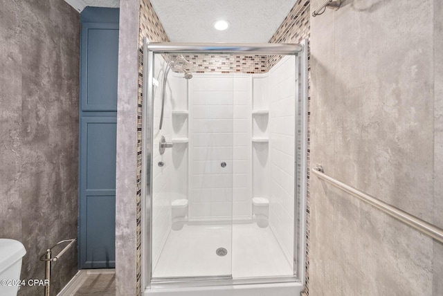 305 S Wells St, Panama City Beach, FL 32413 - full bathroom with a stall shower, a textured ceiling, and toilet