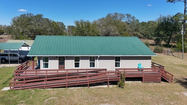 exterior space featuring metal roof, a yard, and a deck