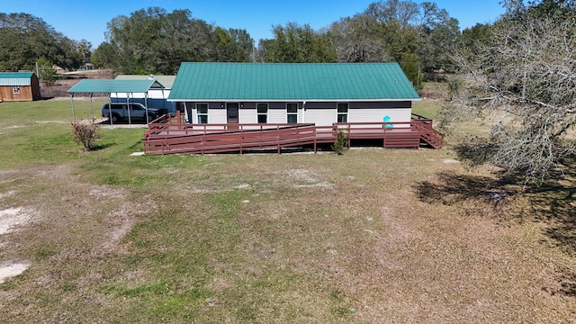 view of front facade with metal roof, a front lawn, a wooden deck, and a detached carport