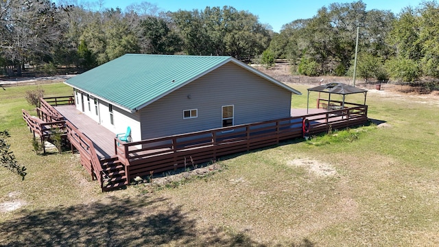 back of house featuring a deck, metal roof, a lawn, and stairs