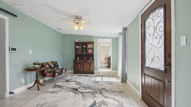 entrance foyer featuring light tile patterned floors, ceiling fan, visible vents, and baseboards