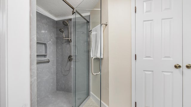 bathroom with a textured ceiling, tile patterned flooring, and a shower stall