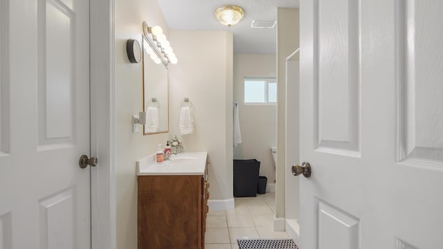 bathroom featuring visible vents, toilet, vanity, tile patterned flooring, and baseboards