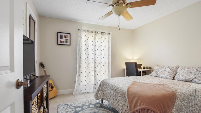 bedroom featuring light tile patterned floors, ceiling fan, a textured ceiling, and baseboards