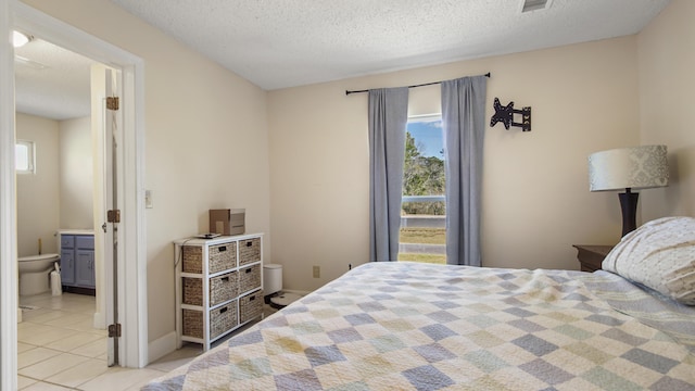 bedroom featuring multiple windows, baseboards, a textured ceiling, and light tile patterned flooring