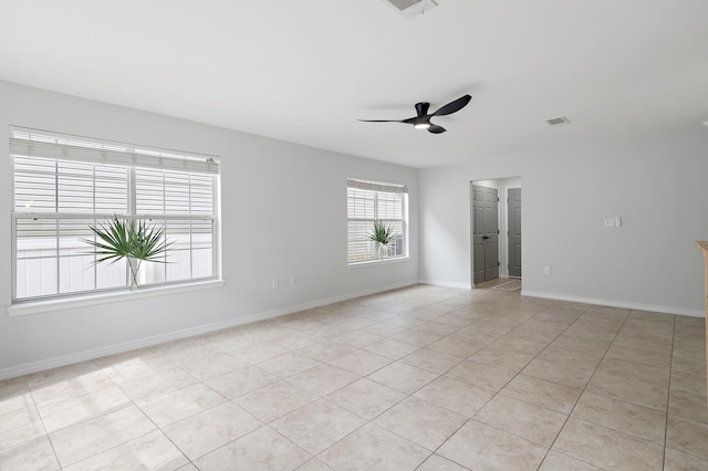 unfurnished room featuring visible vents, light tile patterned floors, a ceiling fan, and baseboards