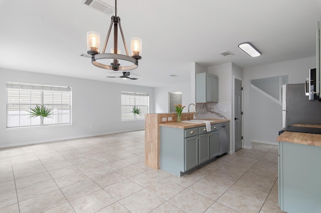 kitchen featuring appliances with stainless steel finishes, visible vents, a sink, and gray cabinetry