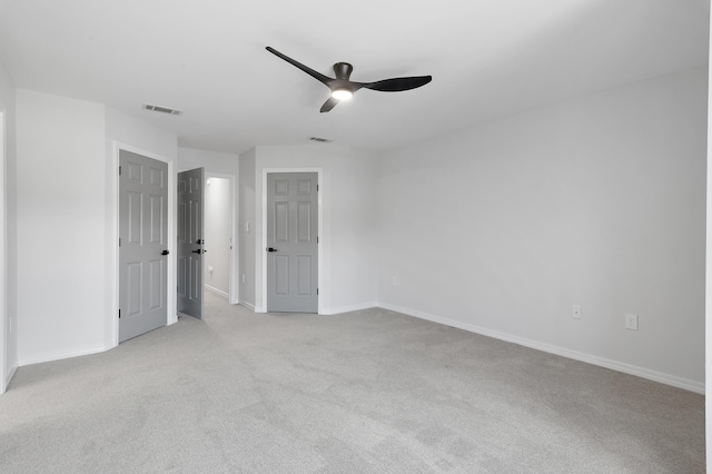 unfurnished bedroom with carpet floors, a ceiling fan, visible vents, and baseboards